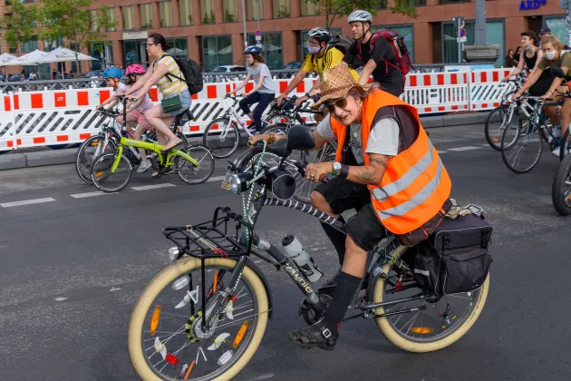 Ältere Frau in oranger Warnweste auf Fahrraddemo